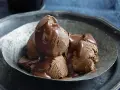 Tre kulor chokladglass, rikligt täckta med varm chokladsås, serveras i en rustik skål. En dröm för alla som älskar helado de chocolate.