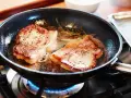 Två saftiga biffar steks i en panna med rosmarin. En perfekt guide för como hacer bistec de carne.