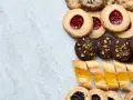 En variation av olika tipos de galletas: syltkakor, chokladkakor med nötter och småkakor med marmelad.