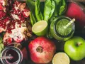 En låda med färska frukter och grönsaker, inklusive granatäpplen, äpplen, lime, rödbetor och gröna smoothies. Perfekt för naturliga botemedel mot gastrit.