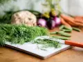 Färska örter, som dill, är utmärkta för att ge smak åt mat. Här ser vi dill förberedd för matlagning tillsammans med andra grönsaker.