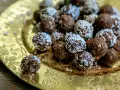 Chokladbollar med **harina de avena** (havregryn) på ett gyllene fat. En är uppäten.
