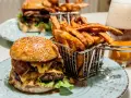 En saftig hamburguesa con papas frites i en korg, redo att avnjutas. En perfekt måltid för en hungrig själ.
