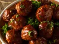 En skål med saftiga köttbullar i en rik, mörk sås, toppade med färsk persilja. Dessa albondigas de carne con salsa ser otroligt goda ut!