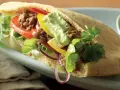 En smakrik pitabrödssmörgås fylld med köttfärs, grönsaker och en krämig sås. Perfekt för snabba och goda **recetas con pan arabe**.