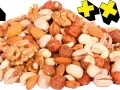 En hög med nötter, som mandlar, valnötter och pistagenötter, med gula kors i bakgrunden. Perfekt för en energiboost!