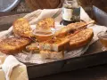 Gylla, gyllene torrejas en miel, serverade på ett fat med honung och en honungsstav.