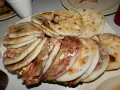 En tallrik med staplade pupusas salvadoreñas, gyllene och fyllda med läckra ingredienser.