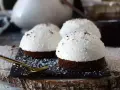 Tre små chokladbakelser med fluffig kokoskräm och strössel. En gyllene sked ligger redo för att njuta av dessa flan de coco.