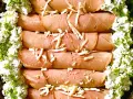 Rullade skinkskivor, enrollados de jamon, toppade med ost och serverade med en krämig ost- och gräslöksröra.