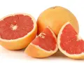En hel och skivad rosa grapefrukt. Denna saftiga pomelo que es är en uppfriskande citrusfrukt.