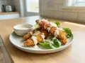 Krispiga kycklingstrimlor med krämig dressing, parmesan och sallad. Enkel guide för como hacer pollo frito.