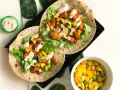 Två kycklingwraps med mango, avokado och sallad. En liten skål med mangosalsa. Hur många kalorier har en tortilla?