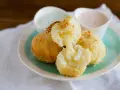 Krispiga papas rellenas de queso med smält ost som rinner ut. Serveras med två dippsåser.