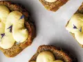 Skivor av saftig sockerkaka med fluffig citronkräm och blå blomblad. Perfekt för en fika, tack vare bakpulver som ger den luftiga konsistensen.