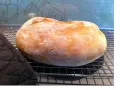 Ett nybakat, fluffigt **pan de torta** vilar på ett galler. En mörk grytlapp ligger bredvid.