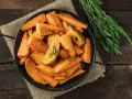 Ugnsrostad batata, eller sötpotatis, i en svart panna med rosmarin. En härlig rätt som visar vad que es batata.