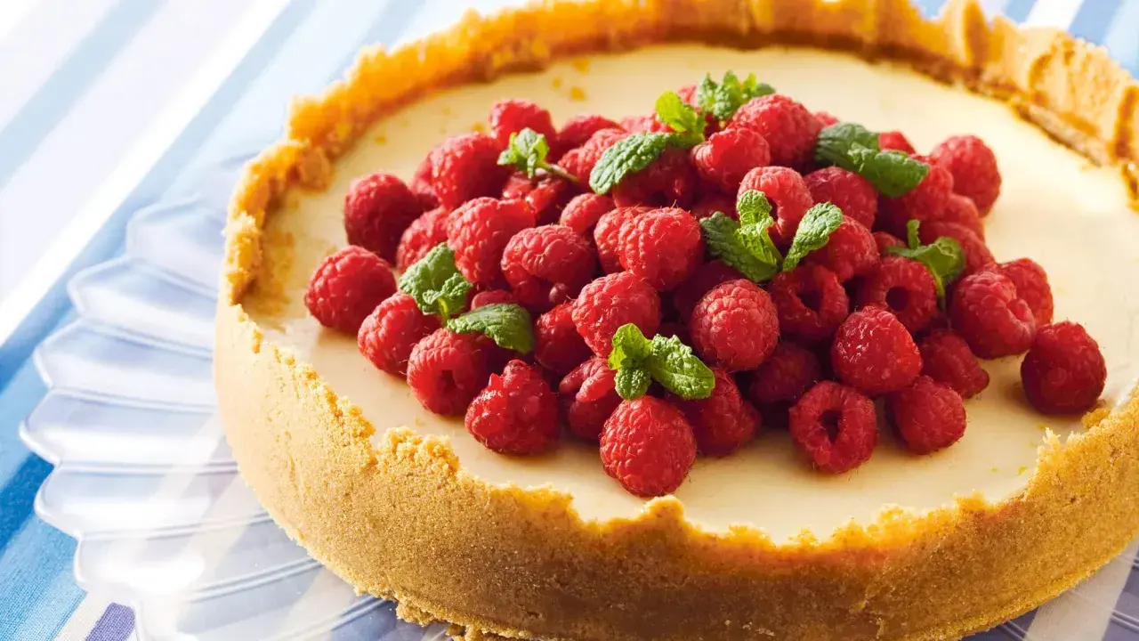 Klassisk ugnsbakad cheesecake med hallon och mynta. En perfekt receta de cheesecake tradicional al horno för alla tillfällen.