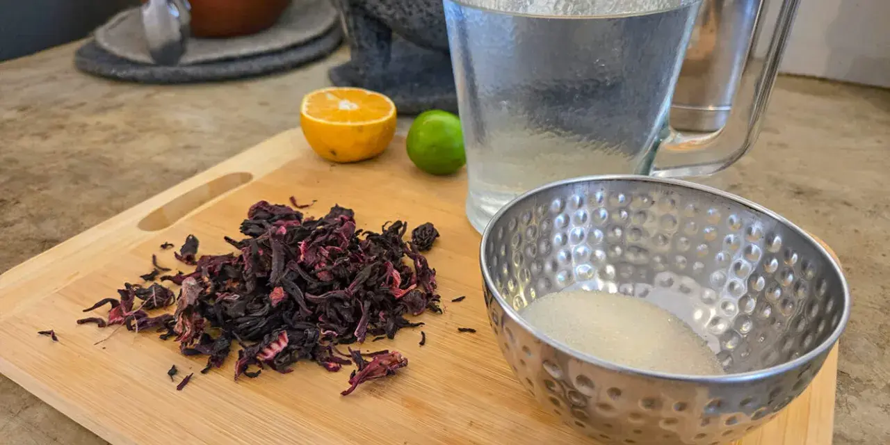 Torkade hibiskusblommor, socker, kanel, lime och apelsin för att göra agua de jamaica, känd för sina hälsofördelar.