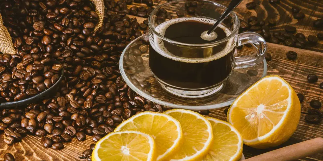 En kopp kaffe med citron, omgiven av rostade kaffebönor. En unik kombination för en café con limón-upplevelse.