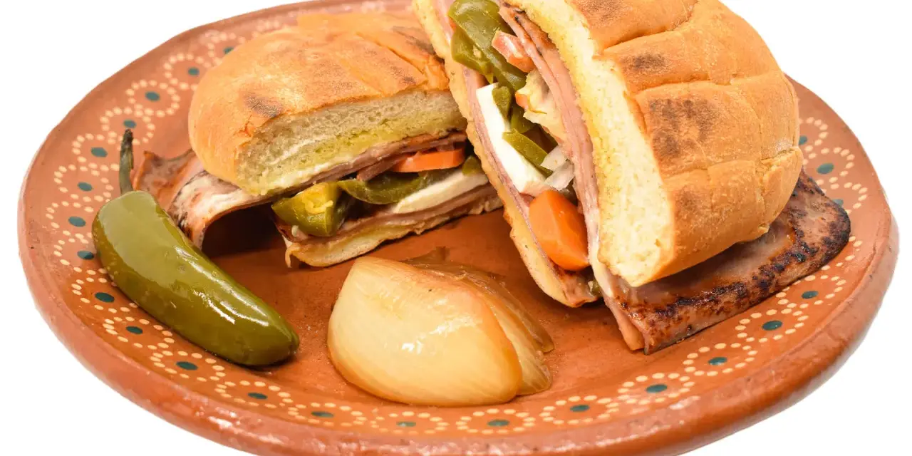 En saftig torta de jamón med jalapeños, morötter och ost på en vacker lertallrik.