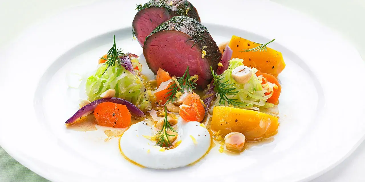 Saftigt lomito con vegetales, med rostade rotfrukter, krispig kål och en krämig sås.