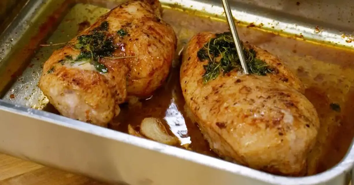 Två saftiga kycklingbröst i en ugnsform, redo att serveras. Perfekt för dina **recetas de pollo**!