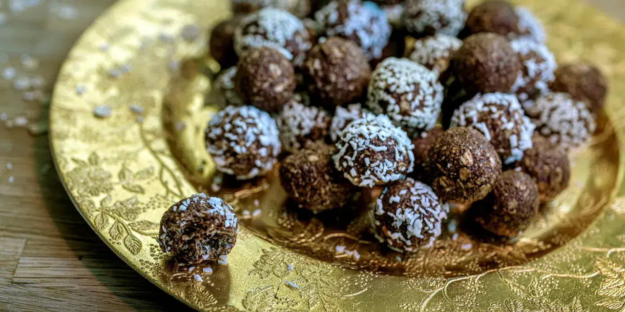 Chokladbollar med **harina de avena** (havregryn) på ett gyllene fat. En är uppäten.