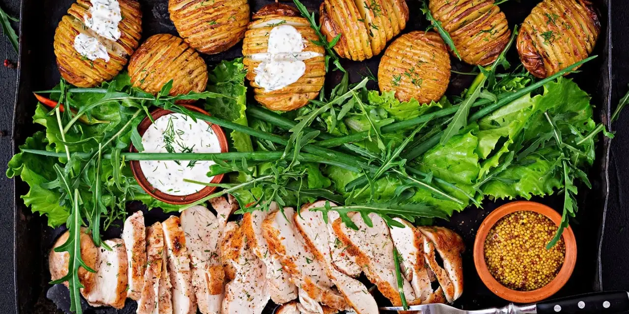 En härlig bricka med saftig kyckling, krispiga Hasselbackspotatisar och fräsch sallad. Perfekt för **cenas saludables y ligeras** – hälsosamma och lätta middagar.