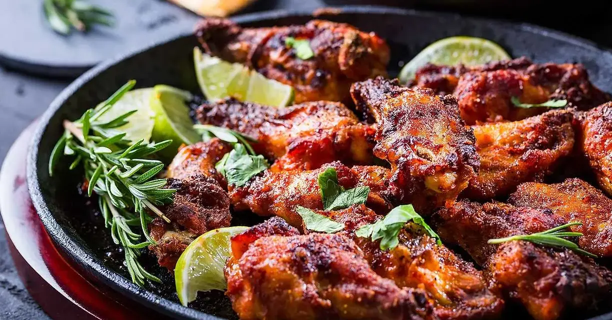 Grillade kycklingvingar med lime och rosmarin, perfekt för att sazonar pechuga de pollo a la plancha.