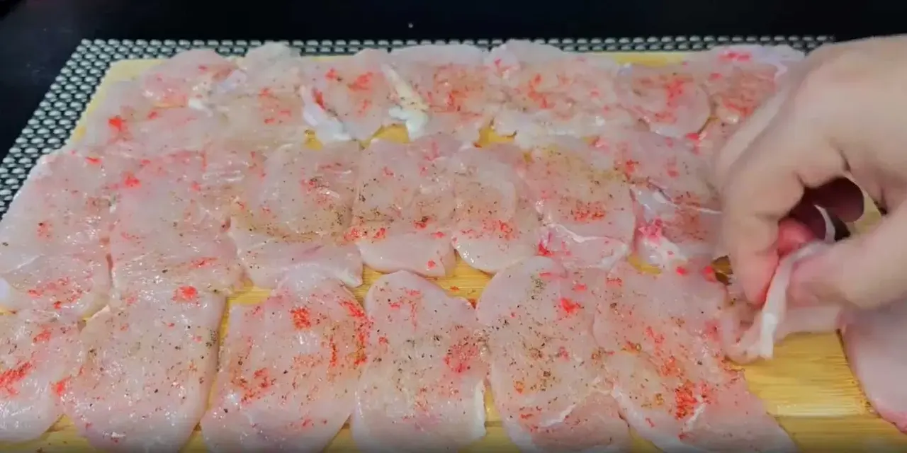 Tunna skivor av kyckling, kryddade med paprika och peppar, ligger redo att bli till saftiga medallones de pollo.