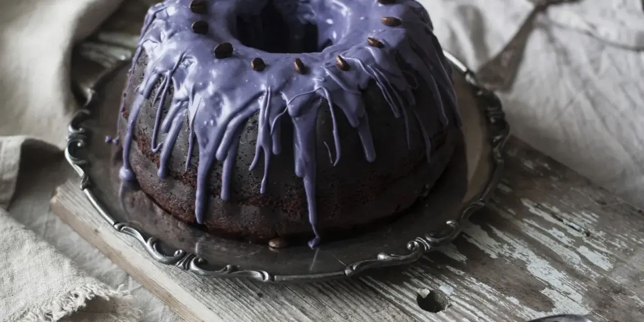 Mörk chokladkaka med lila glasyr och kaffebönor, ett härligt pastel de cafe.