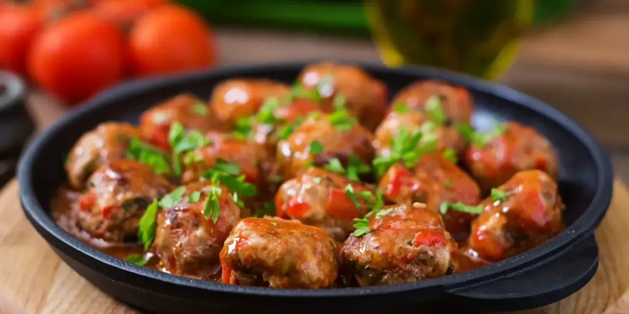 Läckra köttbullar i tomatsås, perfekt för "como hacer albondigas". Garnerade med färsk persilja.