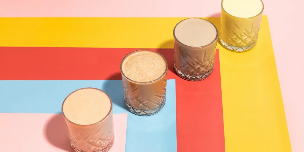 Fyra glas med olika **licuados para bajar de peso** står på en färgglad bakgrund i rött, gult, rosa och ljusblått.