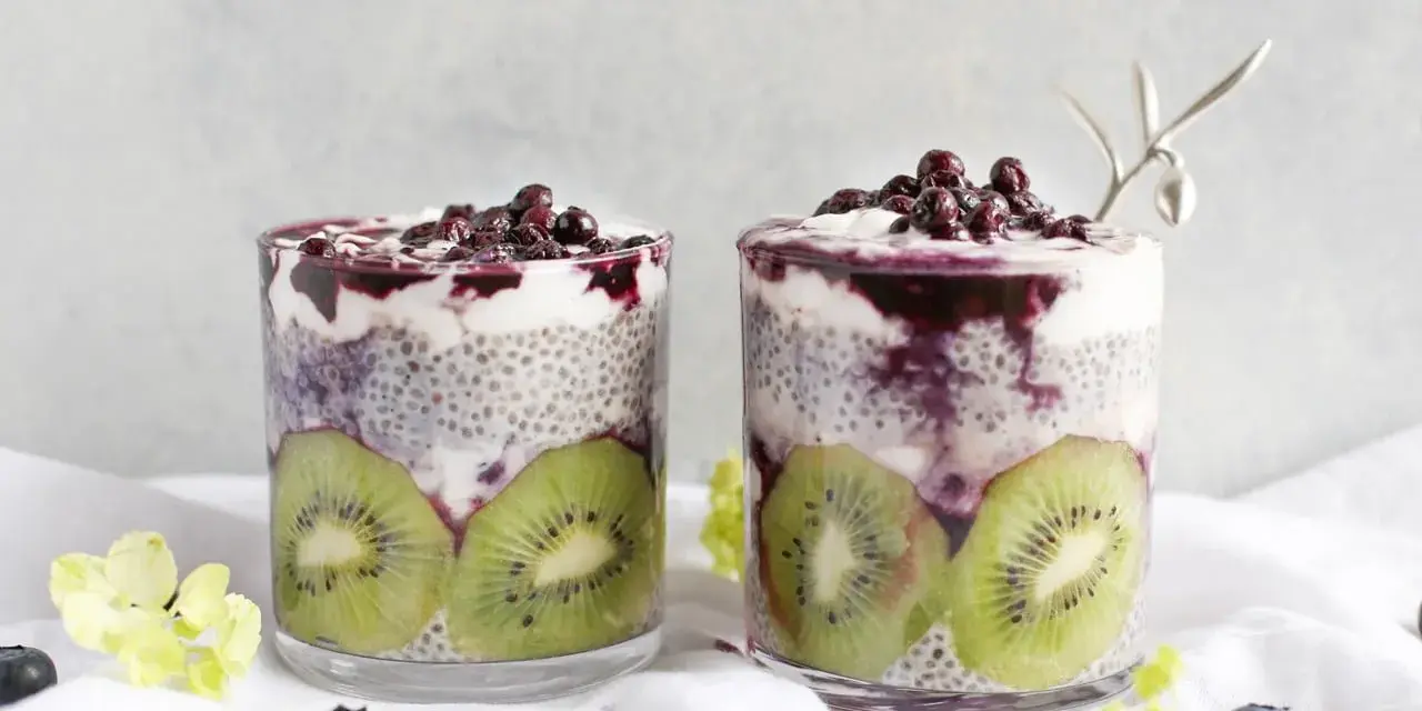Två glas med chiapudding, kiwi och blåbär. En hälsosam frukost med nyttiga semillas de chia.