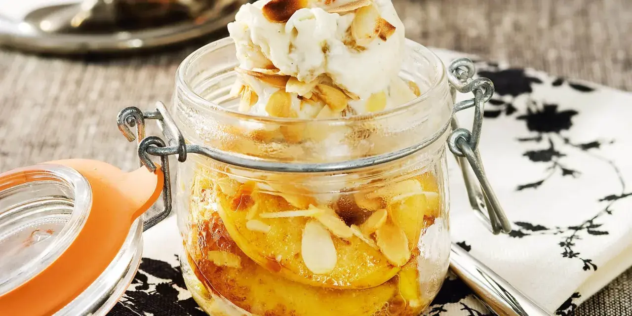 En härlig dessert i glasburk med äppelbitar, mandelflagor och en kula vaniljglass. En perfekt avslutning på måltiden, som en söt ron con pasas.