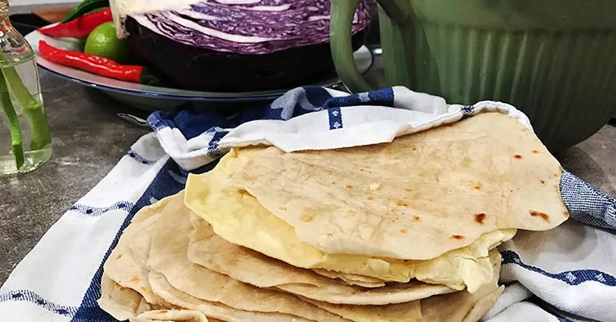 Färska tortillas de harina, redo att fyllas med goda ingredienser. I bakgrunden syns rödkål, chili och koriander.