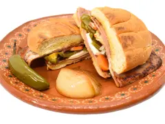 En saftig torta de jamón med jalapeños, morötter och ost på en vacker lertallrik.