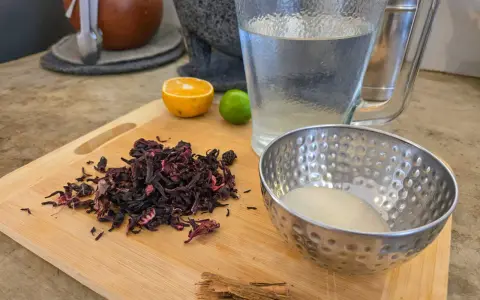Torkade hibiskusblommor, socker, kanel, lime och apelsin för att göra agua de jamaica, känd för sina hälsofördelar.