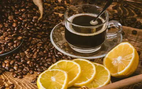 En kopp kaffe med citron, omgiven av rostade kaffebönor. En unik kombination för en café con limón-upplevelse.