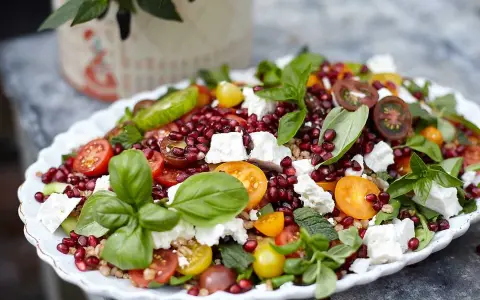 En färgstark sallad med granatäpple, tomater, fetaost och basilika. Perfekt för att visa para qué sirve la ensalada – en hälsosam och god måltid!