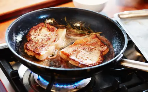 Två saftiga biffar steks i en panna med rosmarin. En perfekt guide för como hacer bistec de carne.
