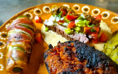 En läcker tallrik med mexikansk mat: en taco med saftig entraña de res, jalapeños inslagna i bacon och en kryddig chorizo.
