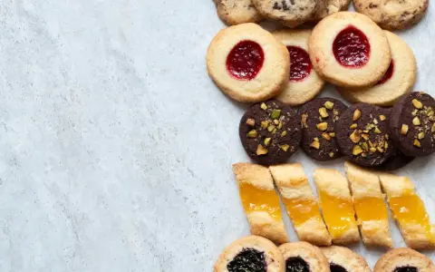 En variation av olika tipos de galletas: syltkakor, chokladkakor med nötter och småkakor med marmelad.