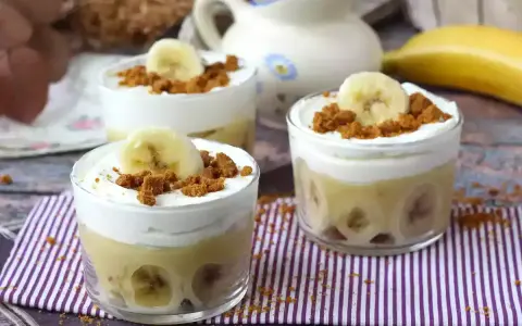 Tre små glas med bananpudding, vispad grädde och krossade kex. Platanos en gloria i sin dessertform.