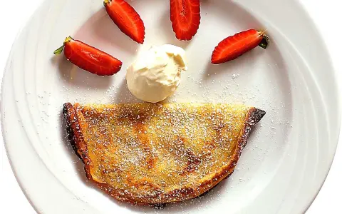 En glad pannkaka med jordgubbar och grädde. Crepas de fresa som ser ut som ett leende.