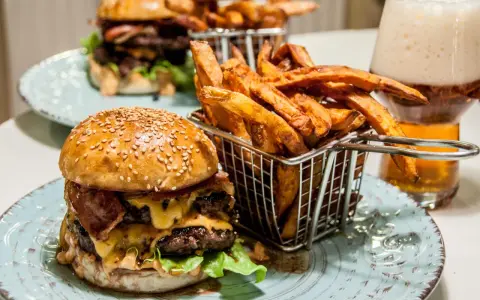 En saftig hamburguesa con papas frites i en korg, redo att avnjutas. En perfekt måltid för en hungrig själ.