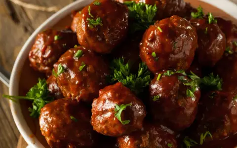 En skål med saftiga köttbullar i en rik, mörk sås, toppade med färsk persilja. Dessa albondigas de carne con salsa ser otroligt goda ut!