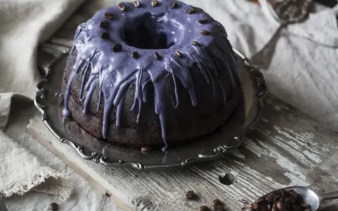 Mörk chokladkaka med lila glasyr och kaffebönor, ett härligt pastel de cafe.