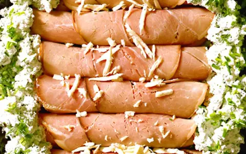 Rullade skinkskivor, enrollados de jamon, toppade med ost och serverade med en krämig ost- och gräslöksröra.